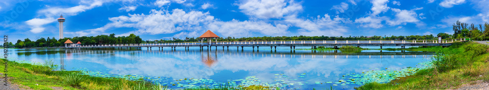 Panorama blue sky with tiny clouds and Bridge over the lake to the observation tower