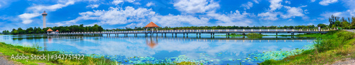 Panorama blue sky with tiny clouds and Bridge over the lake to the observation tower