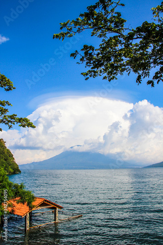 Flooded building by lake surrounded by mountains