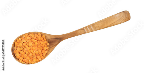 lentils on a wooden spoon isolated on white background
