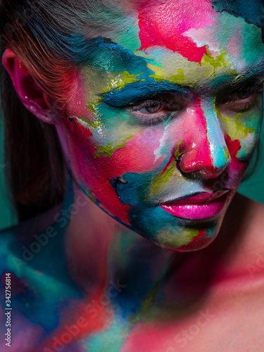 Multicolored skin, difficult to identify. Creative makeup with colorful patterns on the face.