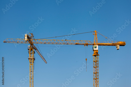 tower cranes on a background of blue sky 