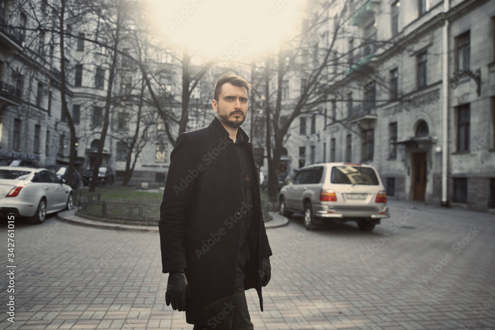 A man in black walks on the street A man in black walks on the street