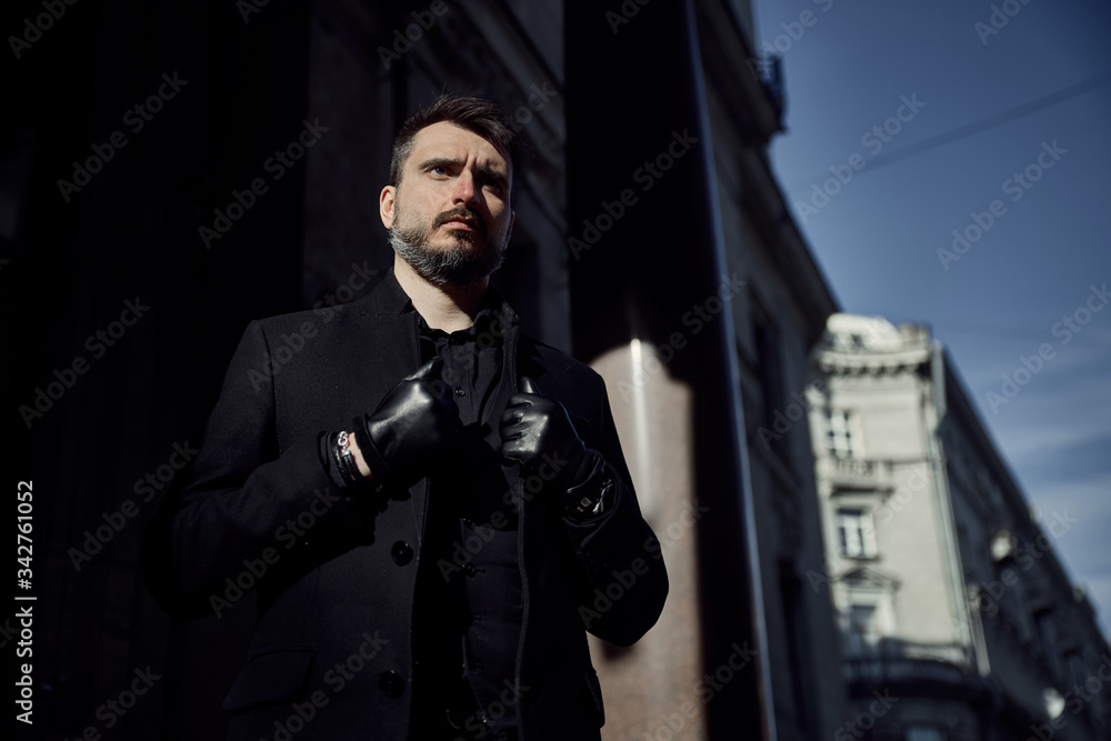 A man in black walks on the street A man in black walks on the street