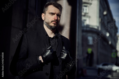 A man in black walks on the street