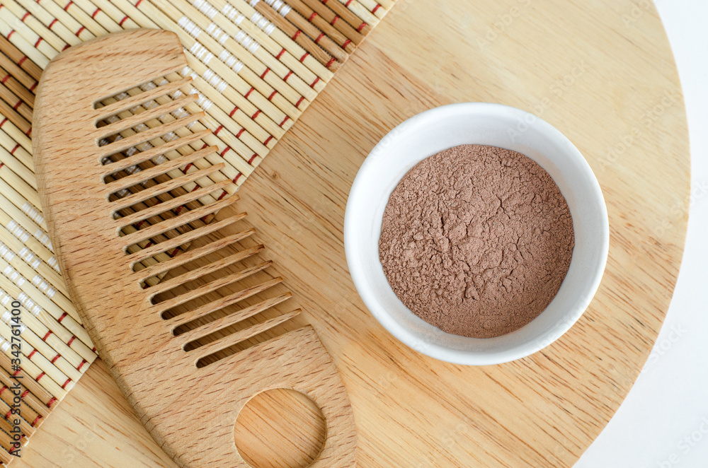 Pink bentonite clay powder in the bowl and hair brush. Clay texture close up. Diy facial or hair mask, dry shampoo and body wrap recipe. Natural beauty treatment and spa. Top view, copy space Pink bentonite clay powder in the bowl and hair brush. Clay texture close up. Diy facial or hair mask, dry shampoo and body wrap recipe. Natural beauty treatment and spa. Top view, copy space