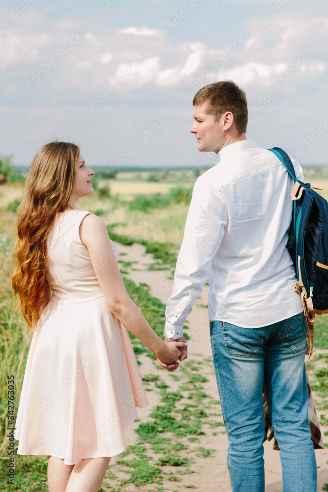 Back view of young couple walking on the nature Back view of young couple walking on the nature