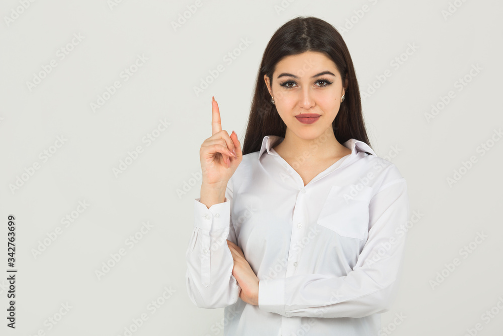 beautiful young woman in a white shirt on a white background with hand gesture
beautiful young woman in a white shirt on a white background with hand gesture