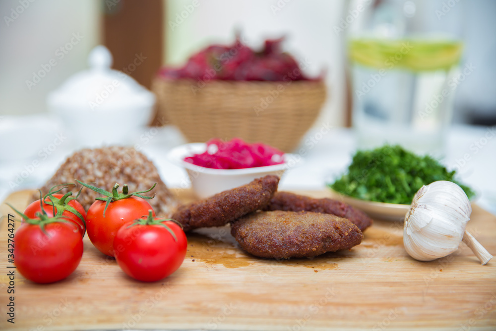 Meat cutlets, baked buckwheat on a wooden board . Red cabbage sauerkraut . Garlic, Onion, Tomatoes. Chopped coriander. Homemade cutlets with oatmeal on a table . Meat cutlets on a wooden skewer . Meat cutlets, baked buckwheat on a wooden board . Red cabbage sauerkraut . Garlic, Onion, Tomatoes. Chopped coriander. Homemade cutlets with oatmeal on a table . Meat cutlets on a wooden skewer .