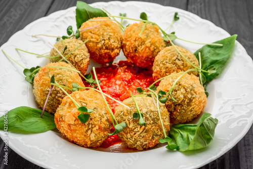 fried meat balls with vegetables and sauce on a plate photo