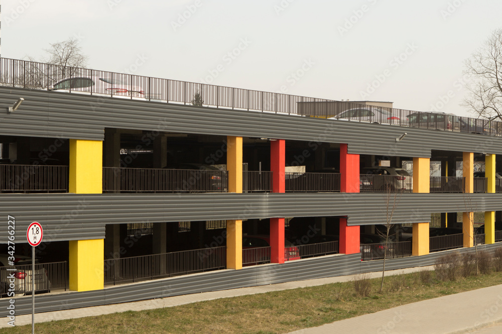modern multi-colored two-level parking lot for cars near a new residential building.