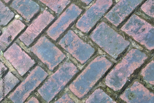 A pathway of old red brick cement for texture background,dirty skin ground floor