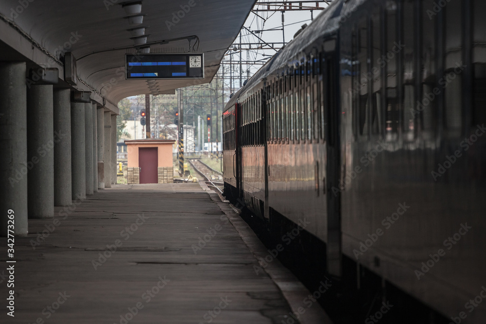 Empty railway station platform with a passenger train ready for departure in a Central European train station Empty railway station platform with a passenger train ready for departure in a Central European train station