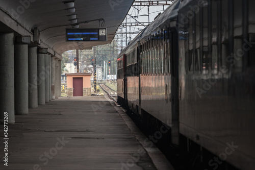 Empty railway station platform with a passenger train ready for departure in a Central European train station