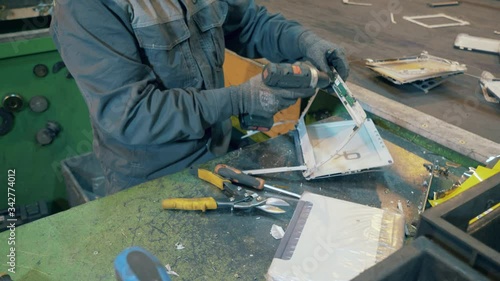 Industrial worker is demounting a discarded computer photo