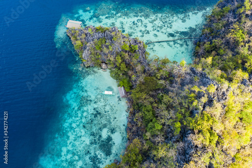 Fototapeta Naklejka Na Ścianę i Meble -  View from above, stunning aerial view of an island surrounded by a beautiful coral reef and bathed by a turquoise, crystal clear sea. Malwawey Coral Garden, Coron Island, Palawan, Philippines.
