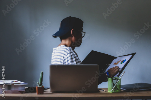 Asian man working from hone online because of covid-19. Work at home and social distancing concept. Selective focus.