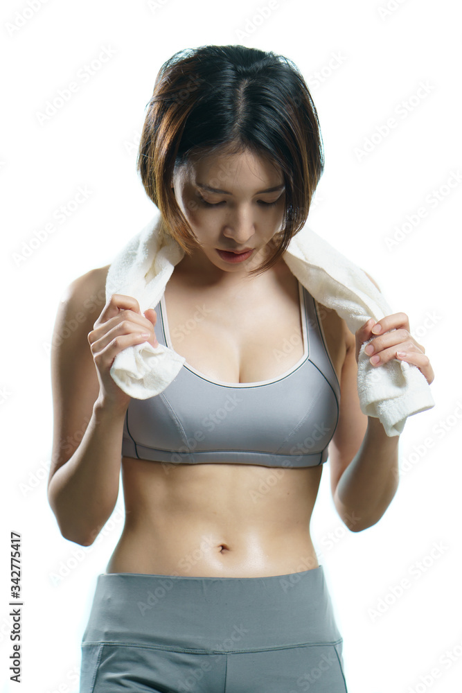 Young woman in gray sportswear with towel taking break after training, in quarantine during Coronavirus pandemic. Young woman in gray sportswear with towel taking break after training, in quarantine during Coronavirus pandemic.