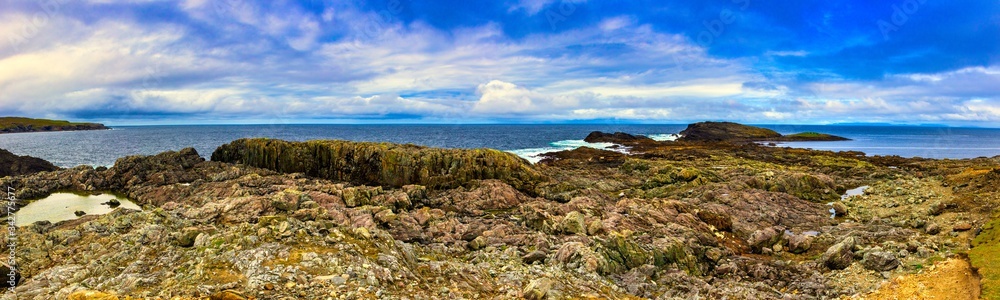 Inishbofin Island ultra wide panorama on the rocks, atlantic ocean and blue sky with clouds