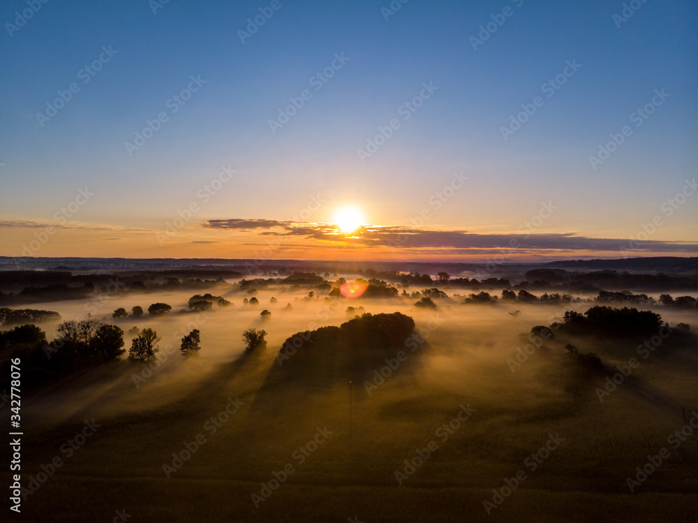 Wonderful sunrise over fields in the fog