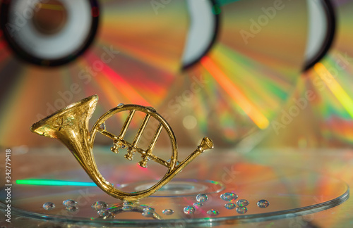French horn on a colored background. Musical instrument, CD, drops. Copy space. photo