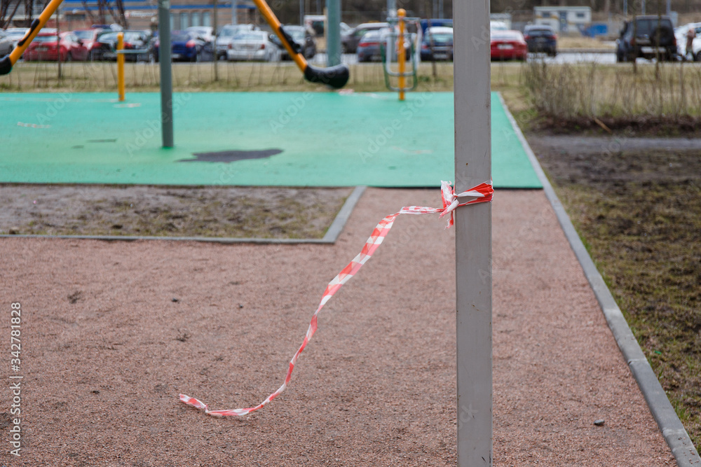Children's playground in the city fenced with a signal red and white ribbon during the prom pandemic of coronavirus covid-19 Children's playground in the city fenced with a signal red and white ribbon during the prom pandemic of coronavirus covid-19