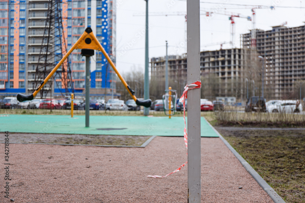 Children's playground in the city fenced with a signal red and white ribbon during the prom pandemic of coronavirus covid-19 Children's playground in the city fenced with a signal red and white ribbon during the prom pandemic of coronavirus covid-19
