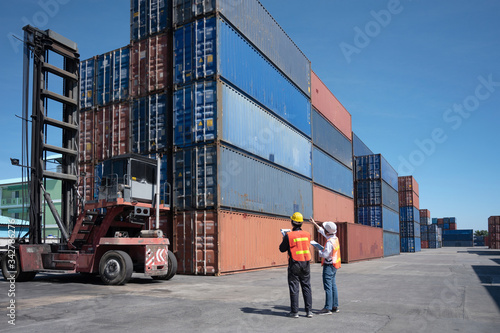 Foreman control loading containers box from cargo freight ship for import export, Foreman control industrial container cargo freight ship, Business import and export logistic concept.