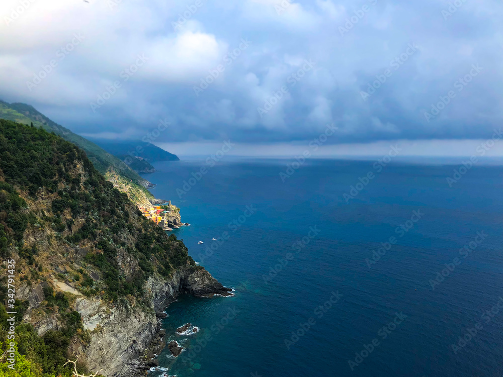 Stunning landscape of Mediterranean turquoise sea and green mountains with vineyards visible from the hiking Cinque Terre trail from Vernazza to Monterosso al Mare in Italy.