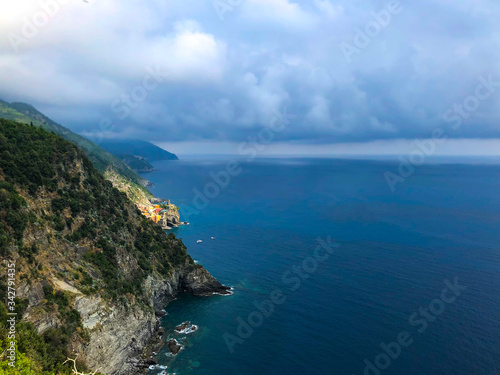 Stunning landscape of Mediterranean turquoise sea and green mountains with vineyards visible from the hiking Cinque Terre trail from Vernazza to Monterosso al Mare in Italy.