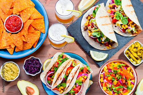 Table with tacos, mango salsa, nachos with sauce, guacamole, lemon beer for Cinco de Mayo celebration party Fototapet