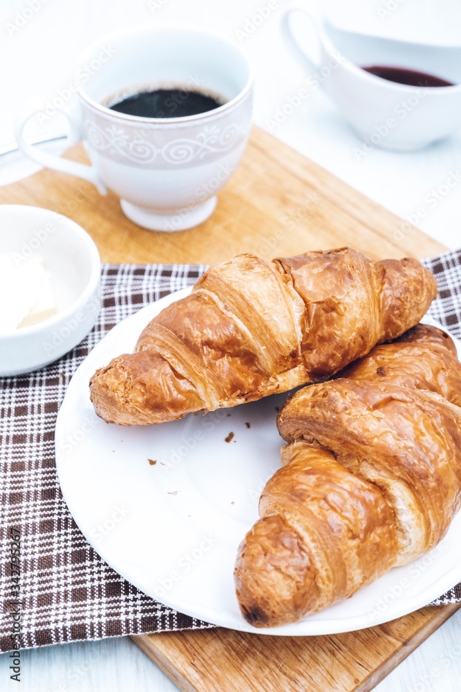 Two homemade croissants with coffee on the table. Tea and pastries for breakfast. Two homemade croissants with coffee on the table. Tea and pastries for breakfast.