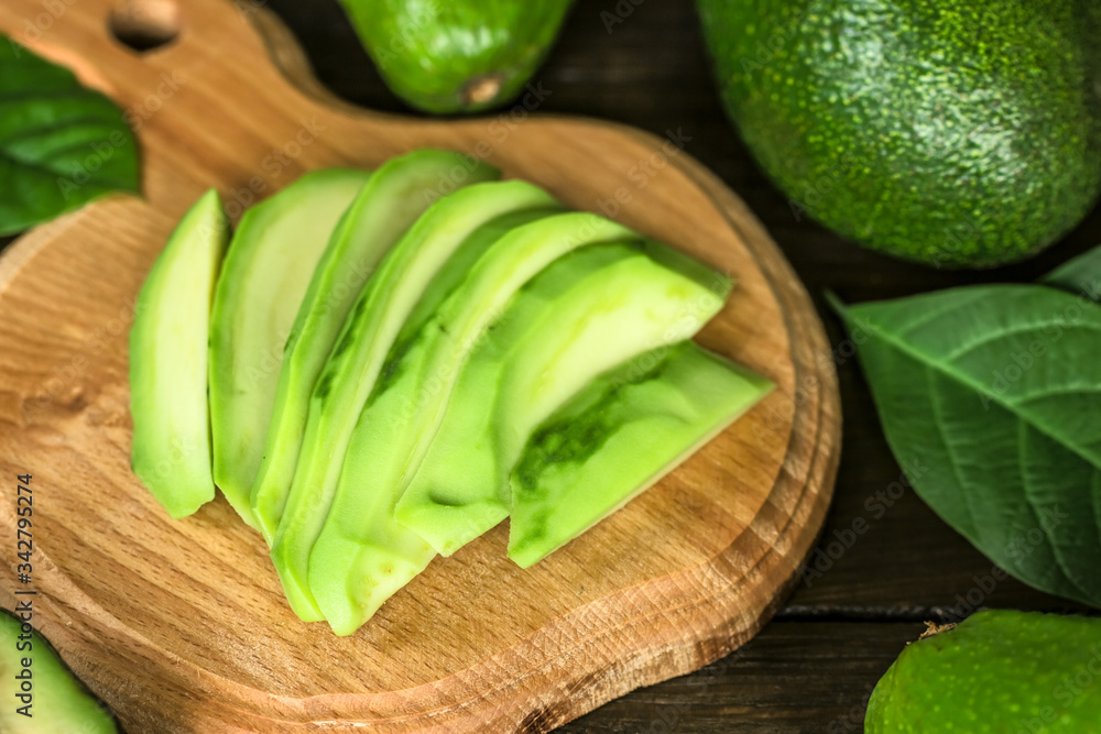 slices of ripe avocado on a wooden cutting board close-up. background with slices of ripe fresh avocado. slices of ripe avocado on a wooden cutting board close-up. background with slices of ripe fresh avocado.