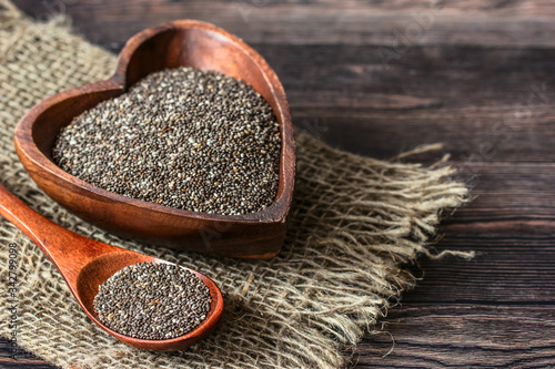 chia seeds in a wooden bowl and spoon on a wooden table and burlap close-up. background with chia seeds. healthy food with chia seeds.