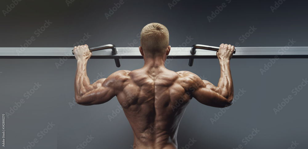 Pull Ups workout in gym. Power muscular bodybuilder on black background. Fitness man pumping up lats muscles. Fitness and bodybuilding training health lifestyle concept horizontal wide photo Pull Ups workout in gym. Power muscular bodybuilder on black background. Fitness man pumping up lats muscles. Fitness and bodybuilding training health lifestyle concept horizontal wide photo