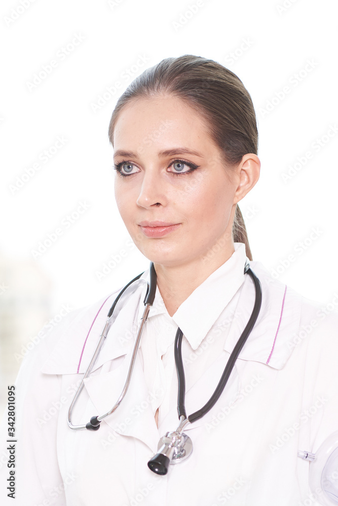 Portrait of a young female doctor with a stethoscope on a white background, she looks away Portrait of a young female doctor with a stethoscope on a white background, she looks away