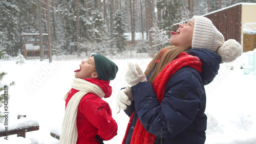 Children catch snowflakes in their mouths. Slowmotion