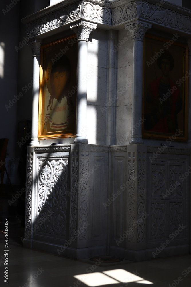 Fototapeta The image of Jesus Christ, the miraculous Savior, on a column in the Orthodox Church, the play of light and shadow, contrasting image, marble carving.