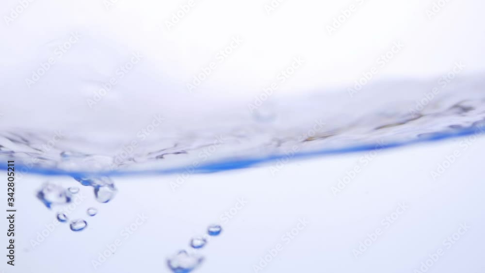 Water splash surface filling the frame with the water drop and waving liquid with an air bubble on a white background. Slow motion 1080p 23.98fps Water splash surface filling the frame with the water drop and waving liquid with an air bubble on a white background. Slow motion 1080p 23.98fps