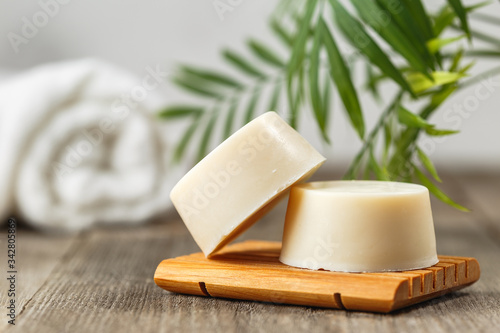 Eco friendly solid shampoo soap bar on wooden dish photo