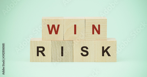 win and risk words on wooden blocks isolated on blue background business choice and strategy concept