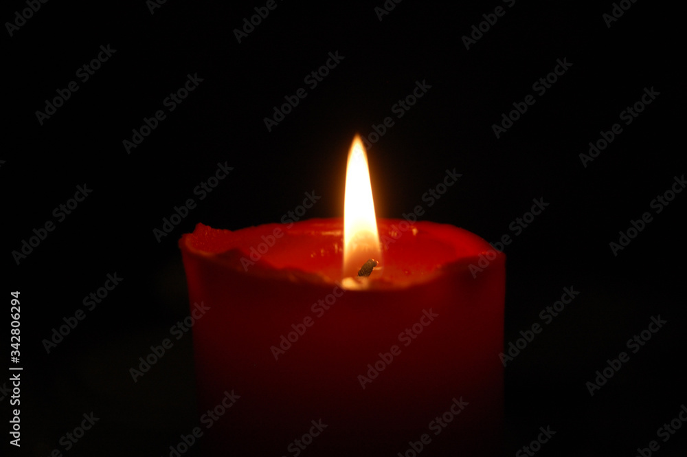 Red candle on a black background Red candle on a black background