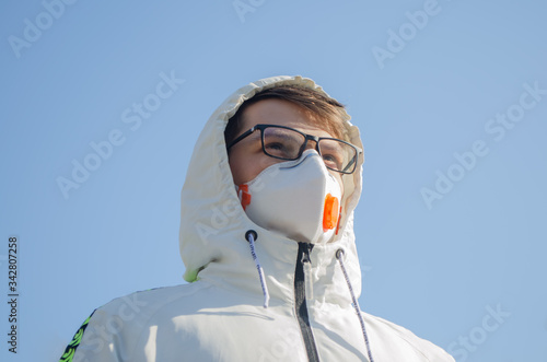 ManYoung man with n95 mask against blue sky photo