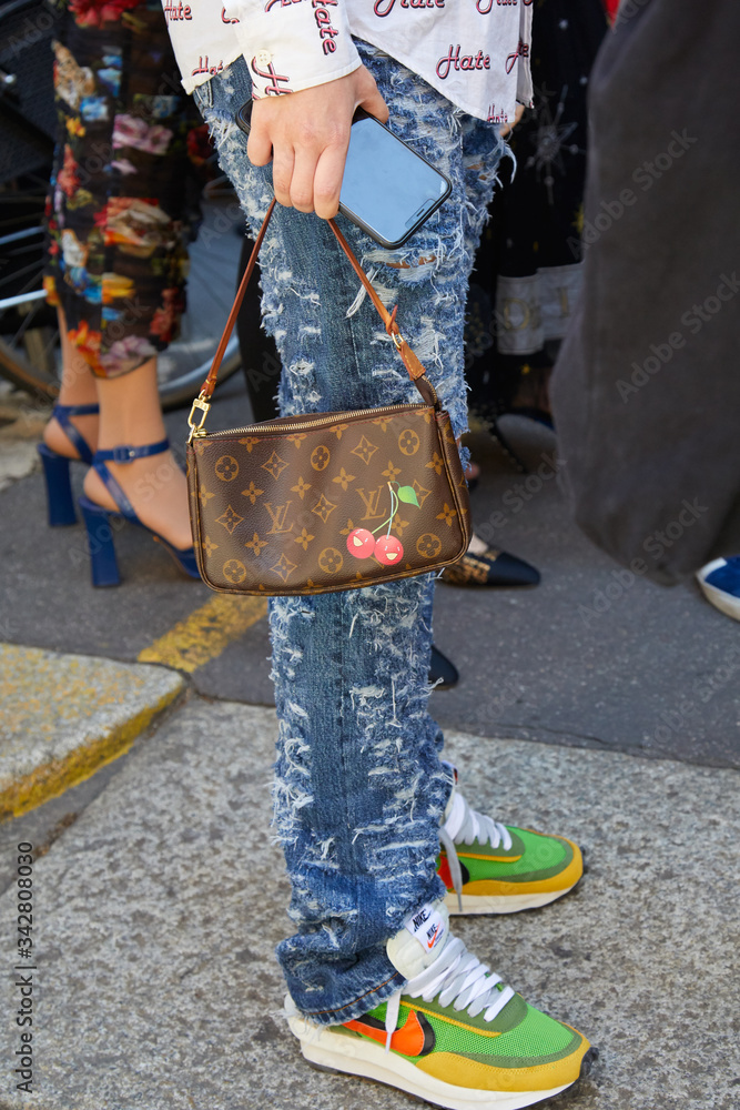 Woman with Torn Denim Trousers, Louis Vuitton Bag and Nike