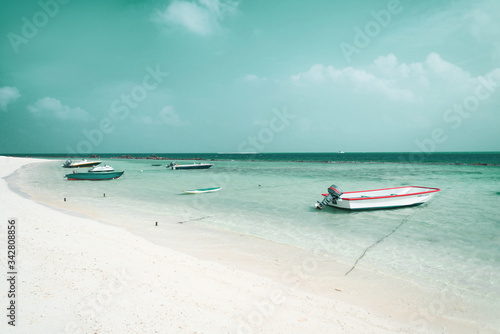 Rajska tropikalna plaża, zakotwiczone małe łódki oraz motorówki.