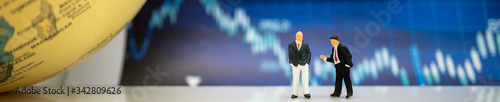 Miniature people: Businessmanon with blue graph stock using as background business investment money, financial, business growth cover page concept.
