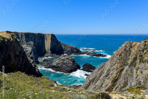 Portugal, Beja, Farol Cabo Sardão, Cabo Sardao - Ein beeindruckender Steilküstenabschnitt mit nistenden Störchen auf den Klippen. Drum herum ist alles bunt bewachsen mit wilden Blumen.