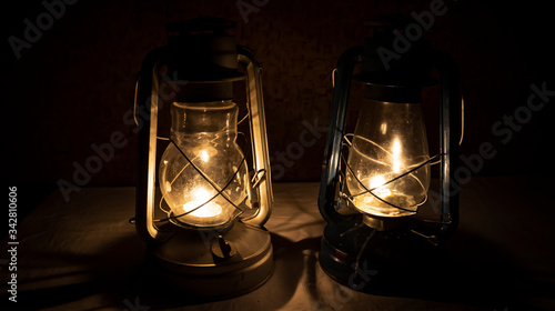 The old oil lamp in dark on the table is suitable for decorating mysterious scenes