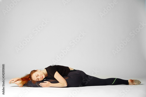 The girl lies in twine and sleeps after a workout on a white background.