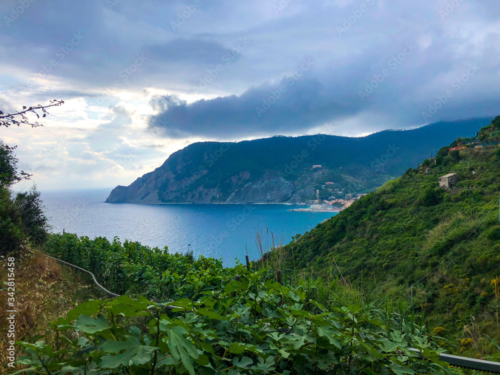 Beautiful scenic view of Mediterranean turquoise sea and green mountains with vineyards visible from the hiking Cinque Terre trail from Vernazza to Monterosso al Mare in Italy.